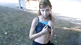 Худа руда сексуальна дівчина в парку показує свою маленьку дупу оголеною