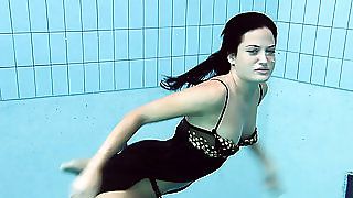 Чиста темна брюнетка краси під водою в басейні на камеру